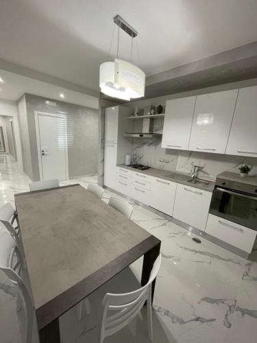 a kitchen with a wooden table and white cabinets at B&B IL PICCOLO PRINCIPE in Mercato San Severino