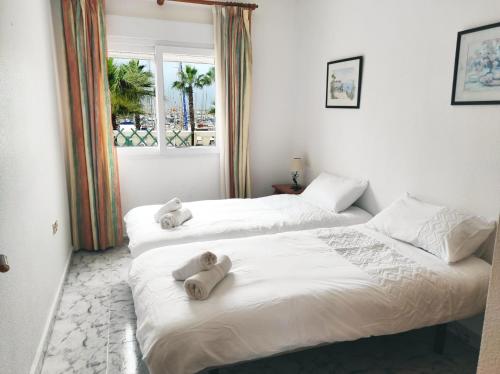 two beds with stuffed animals on them in a bedroom at Marina Sunrise Puerto in Torrevieja