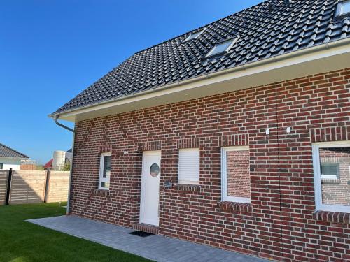 a red brick house with a white door at Wangerbrise in Wangerland