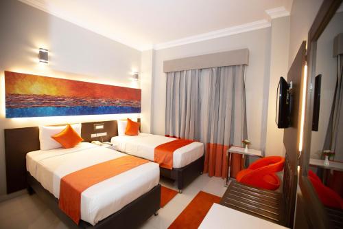 a hotel room with two beds and a television at Gloria Aqua Park Hotel in Aswan