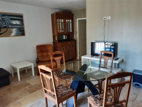 a dining room with a glass table and chairs at Au pays du Ventoux in Le Thor