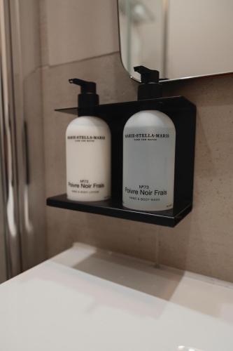 two soap bottles on a shelf in a bathroom at The Times Hotel in Amsterdam