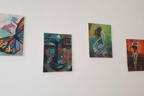 a group of paintings hanging on a wall at Lola seaview guest house. Уютный Домик в Варне in Varna City