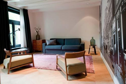 - un salon avec un canapé bleu et des chaises dans l'établissement Hotel IX Nine Streets Amsterdam, à Amsterdam