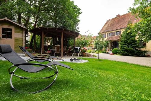a yard with a gazebo and a bench in the grass at Ferienwohnung Nesselbachtal in Neustadt an der Aisch