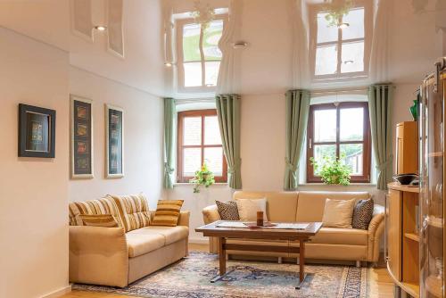 a living room with two couches and a table at Ferienwohnung Nesselbachtal in Neustadt an der Aisch
