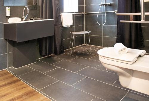 a bathroom with a toilet and a sink at TU Hotel by WMM Hotels in Tuningen