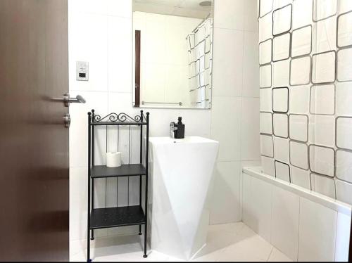 a white bathroom with a sink and a mirror at Upgraded 2 bedrooms to 3 bedrooms Private Residential Apartment In C4 Tower in Hydra Avenue Towers in Al Reem Island - 1307 in Abu Dhabi