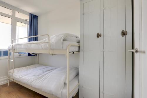 a room with two bunk beds and a closet at DE TRINTEL met zeezicht in Egmond aan Zee