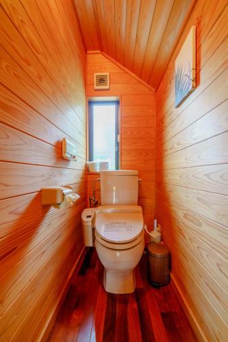 a bathroom with a toilet in a wooden room at Hosu in Izunokuni