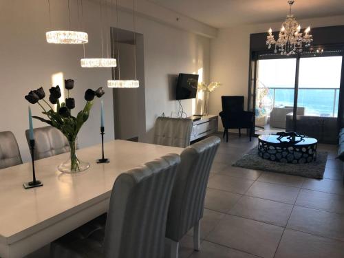a dining room and living room with a table and chairs at Panorama Apartment " City Garden " in Bat Yam