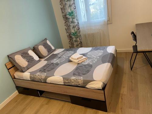 a bed with two pillows on it in a bedroom at Charmante chambre in Montpellier