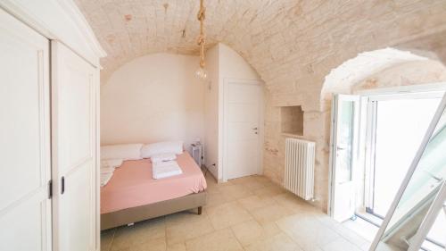 Un dormitorio pequeño con una cama y una ventana. en Martina Trulli Relais, en Locorotondo