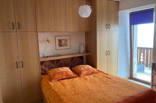 1 dormitorio con 1 cama con 2 almohadas en Bel appartement 2.5 pièces avec balcon, magnifique vue sur le glacier des Grands en Finhaut