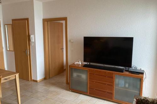 a flat screen tv sitting on top of a wooden entertainment center at Bel appartement 2.5 pièces avec balcon, magnifique vue sur le glacier des Grands in Finhaut