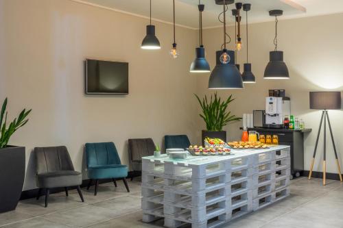 a room with a table and chairs and lights at Hotel Oberhausen Neue Mitte affiliated by Meliá in Oberhausen