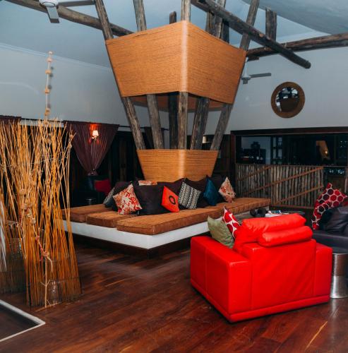 a living room with a red couch and a red chair at Escarpment Luxury Lodge Manyara in Mto wa Mbu