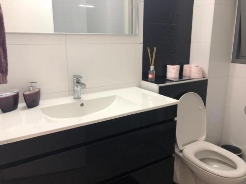 a white bathroom with a sink and a toilet at Panorama Apartment " City Garden " in Bat Yam