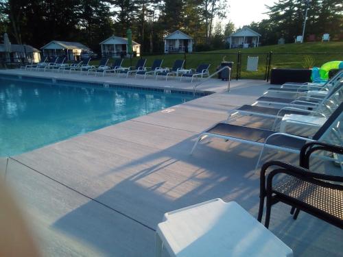 a row of chairs sitting next to a swimming pool at Grand View Resort in Weirs Beach