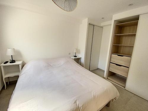 um quarto com uma cama branca e um closet em Superbe appartement au cœur du Cap d'Antibes em Antibes