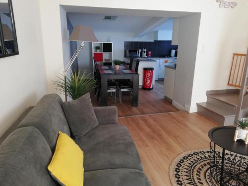 un salon avec un canapé et une salle à manger dans l'établissement Les Pénates, à Saint-Laurent-sur-Sèvre