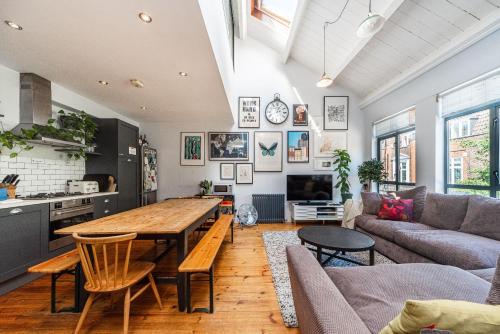 Pass the Keys - Trendy flat with private terrace in Central East London في لندن: مطبخ وغرفة معيشة مع طاولة خشبية