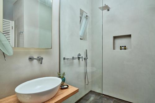 a bathroom with a white sink and a shower at Meltemi Excelsior Suites in Perissa
