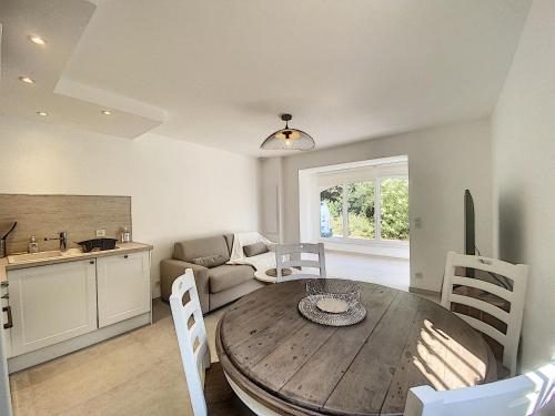 Il comprend un salon avec une table en bois et une cuisine. dans l'établissement Superbe appartement au cœur du Cap d'Antibes, à Antibes