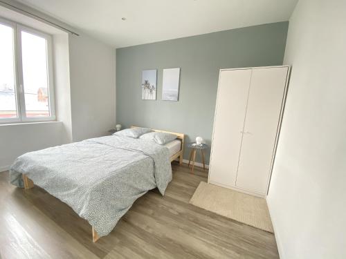 a white bedroom with a bed and a cabinet at Magnifique T2 40m2 lumineux, moderne et rénové avec fibre in Belfort