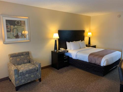 科迪爾的住宿－科迪爾品質酒店，配有一张床和一把椅子的酒店客房