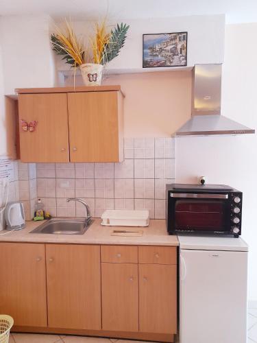 a small kitchen with a sink and a microwave at Delfini in Akhladherí