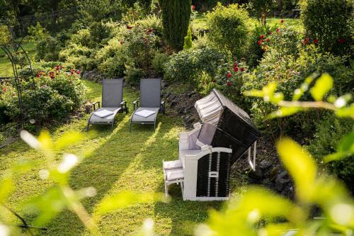 a group of chairs sitting in a garden at Hotel Pistono in Dieblich