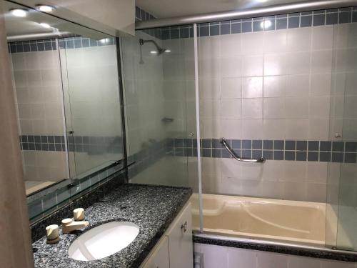 uma casa de banho com um lavatório, um chuveiro e uma banheira em Iate Plaza Beiramar Fortaleza app1006 em Fortaleza
