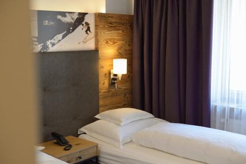 a bedroom with a bed with a table and a window at Haus Steffeler in Sankt Anton am Arlberg
