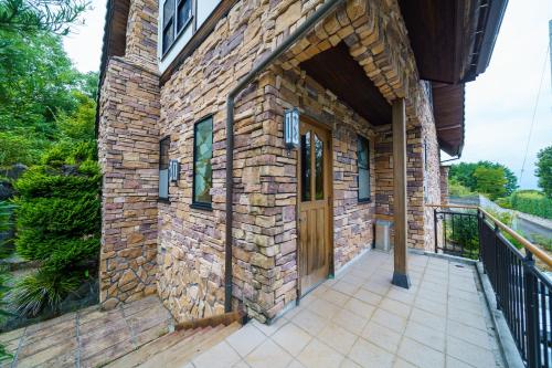 a brick building with a wooden door on a patio at Hosu in Izunokuni