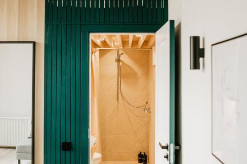 baño con ducha y puerta verde en Birštonas Tiny Hemp House, en Birštonas