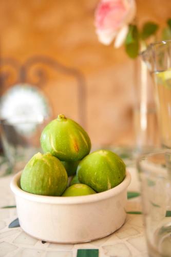 a bowl of green limes sitting on a table at Domaine de Cantegrel - Gîtes de Charme et Suite Troglodyte en Périgord in Vitrac