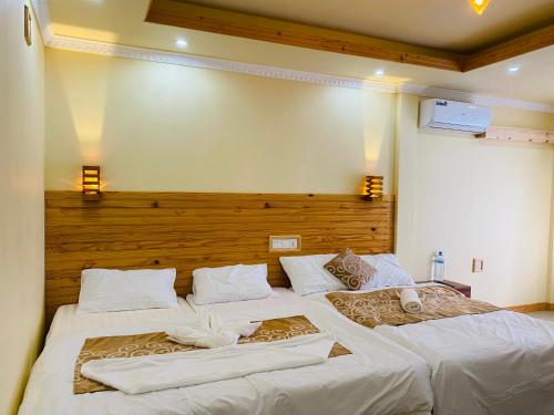 a bedroom with two beds with white sheets at Mariana Inn in Gaafaru