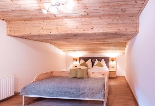 uma cama num quarto com tecto em madeira em Haus Rabl em Itter