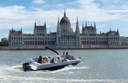 a group of people on a boat in the water in front of a building at B12 Apartment Budapest in Budapest