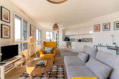 un salon avec un canapé et une table dans l'établissement Le Manhattan - Grand 3 chambres - Vue panoramique, à Nantes