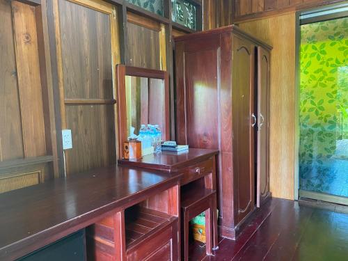 a room with a wooden desk and a cabinet at Tharathip Resort Koh Phangan - SHA Plus in Wok Tum