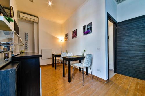 eine Küche und ein Esszimmer mit einem Tisch und Stühlen in der Unterkunft E-Room 42 in Rom