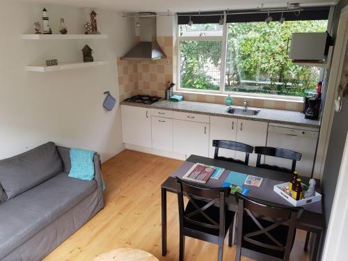 een woonkamer met een bank en een tafel en een keuken bij Ferienhaus Abenteuer in Egmond aan Zee
