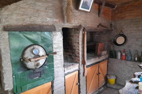 a kitchen with a green oven in a brick wall at Cabaña Pirayú in Oliveros