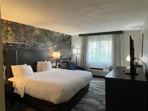 a hotel room with a bed and a television at Clarion Inn Fairborn - Dayton near Wright Patterson in Fairborn