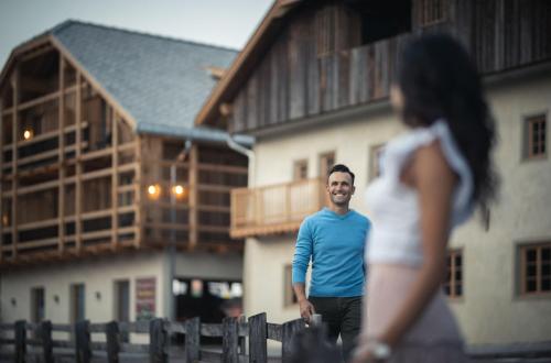 a man and a woman walking in front of a house at Autentis in Rasùn di Sotto