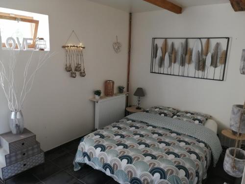 a bedroom with a bed and a vase on a table at Séjour à la campagne in Bouhy