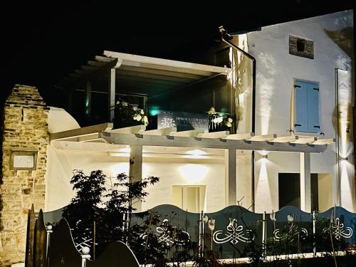 a white house with a porch at night at Dimora di Charme Rooms & Apartments in Peschiera del Garda