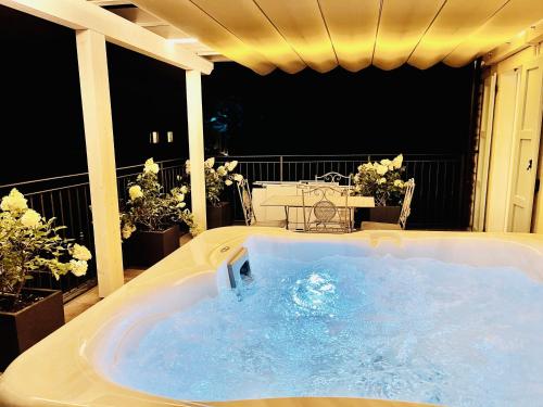 una vasca idromassaggio su un balcone fiorito di Dimora di Charme Rooms & Apartments a Peschiera del Garda